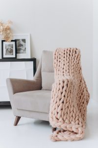 A nice tan chair with a cozy knit blanket hanging off it - Excellent Advice for Living