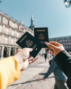 A picture of two hands holding passports - Splurge on your passions - Excellent Advice for Living